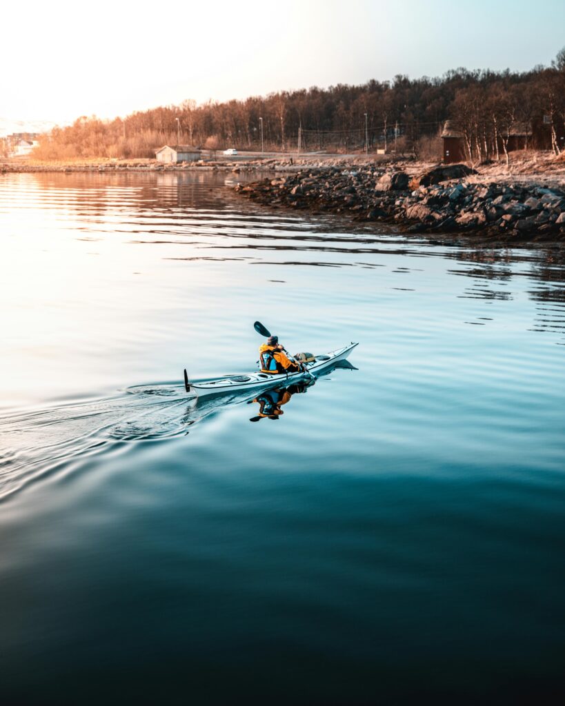 A kayak angler casting at sunrise in Florida Keys backcountry, turquoise water, mangrove tunnels, tarpon leaping in distance. Cinematic drone shot, hyperrealistic.