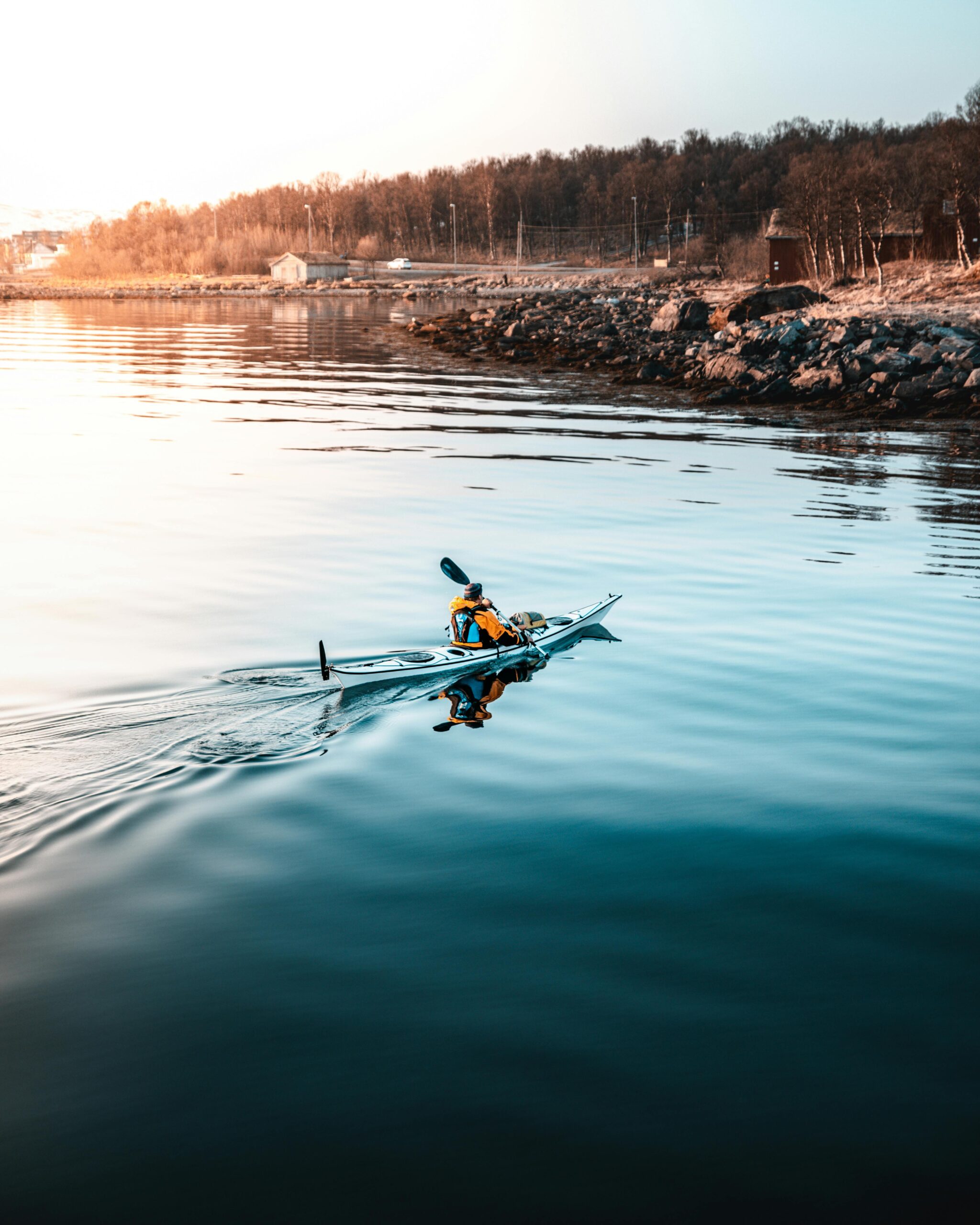 A kayak angler casting at sunrise in Florida Keys backcountry, turquoise water, mangrove tunnels, tarpon leaping in distance. Cinematic drone shot, hyperrealistic.